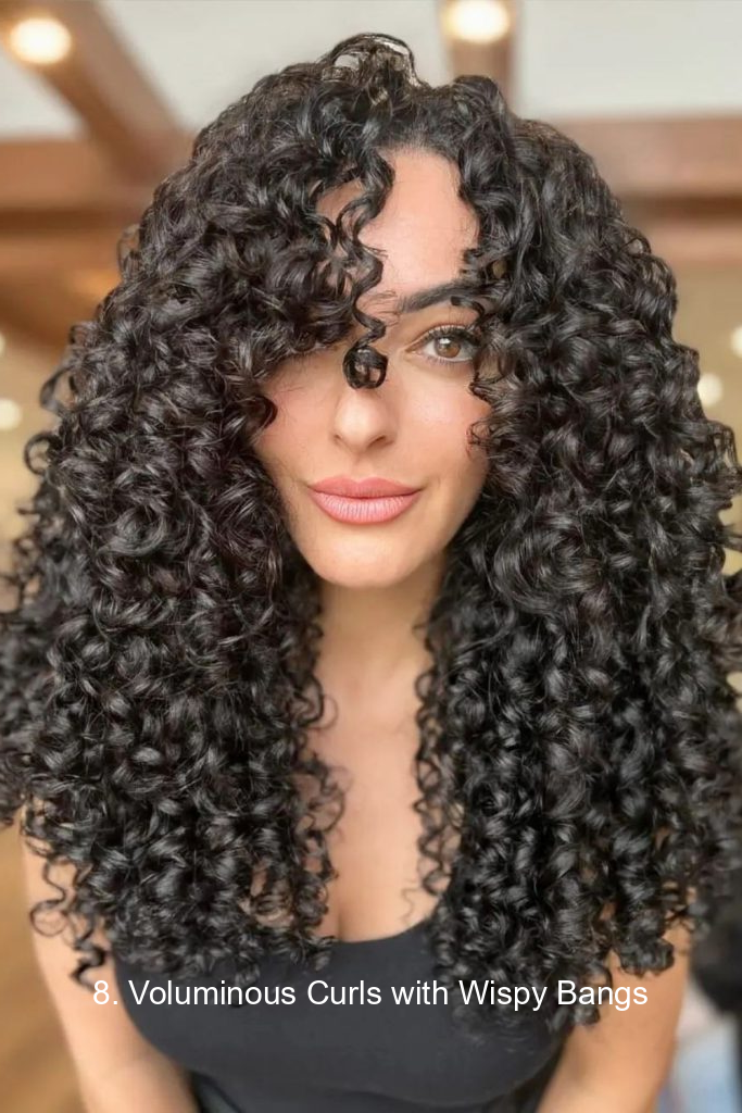 8. Voluminous Curls with Wispy Bangs
